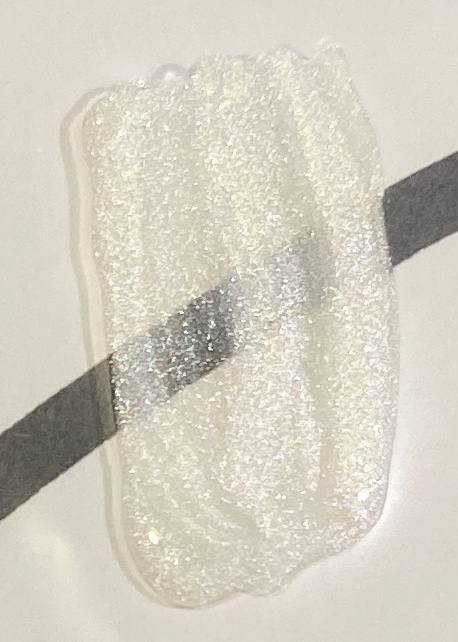 Bilde av fargeprøve tatt i lampelys, hvitt ark med sort tusjstrek som bakgrunn for å vise dekkevne. Lagt tynt er den transparent, med to strøk er den mer dekkende.